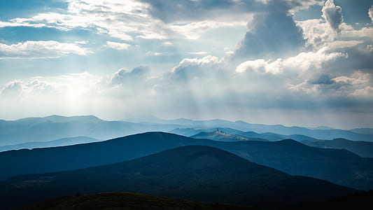mountain range under blue cloudy skies thumbnail