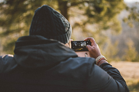 man in black hoodie holding black camera thumbnail