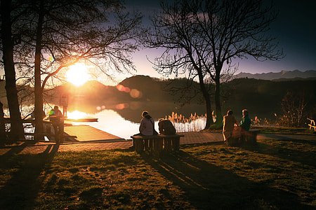 two person sitting on bench in front of lake during sunset thumbnail