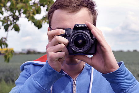 person holding Canon camera thumbnail
