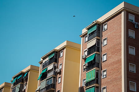 brown and red condominiums during daytime thumbnail