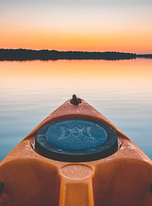 orange kayak on body of water thumbnail