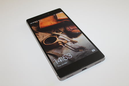 turned-on black smartphone on beige surface thumbnail