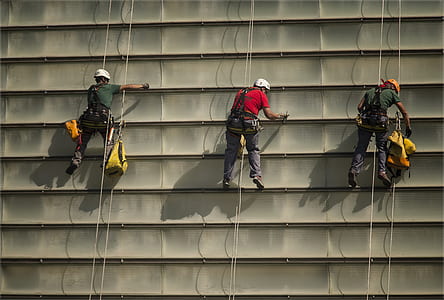 three men cleaning wall while on harness thumbnail
