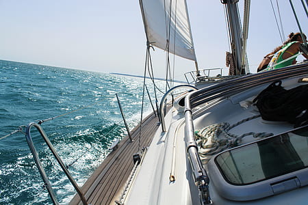 white yacht leaned on body of water during daytime thumbnail