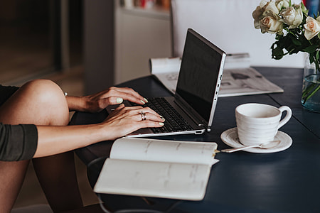 Woman using a laptop by a round breakfast table thumbnail