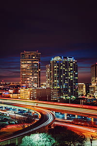 time lapse photography of road beside high-rise building thumbnail