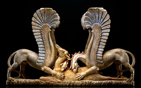two brown winged animals biting brown camel figurine thumbnail