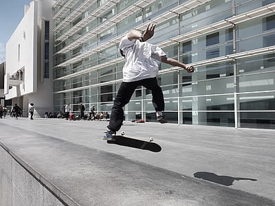 man jumping on skateboard in front of building thumbnail