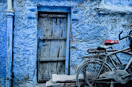 several bicycles near brown wooden door thumbnail