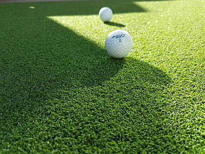two white golf balls on green grass thumbnail