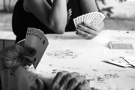 two people playing cards in grayscale photography thumbnail