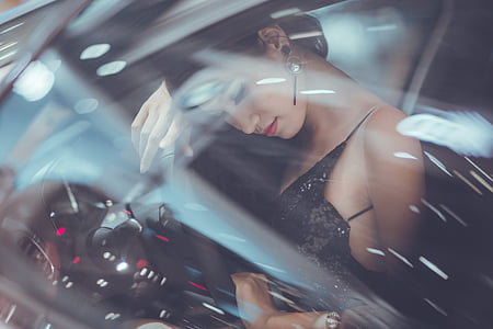 woman in black spaghetti strap top inside car thumbnail