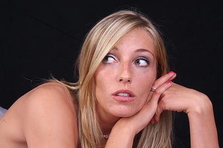 close-up photo of woman with red lipstick posing for photo with black background thumbnail