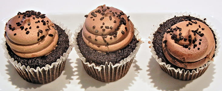 three chocolate cupcakes with icing and chocolate bits thumbnail