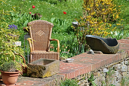 brown wicker armchair near green plants outdoors thumbnail