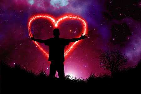 silhouette of person in the middle of a heart shape firework at night thumbnail