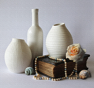 three white ceramic vases and brown book thumbnail