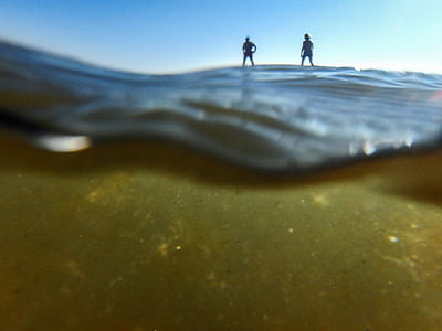 surreal photography of two persons on body of water thumbnail
