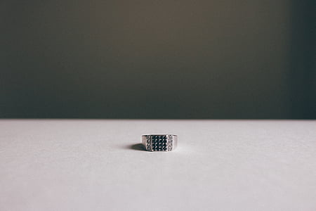 silver-colored black gemstone encrusted ring on beige surface thumbnail