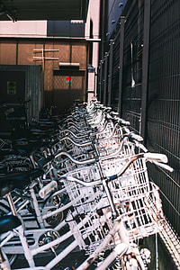 white bike lot beside black metal fence thumbnail