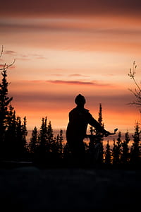 man holds bike looking up during golden hour thumbnail