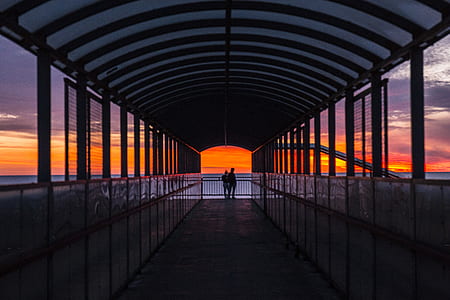 silhouette photo of two persons on metal made hallway thumbnail