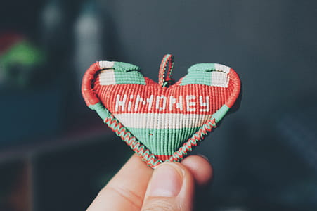 Person Holds Red and Teal Himoney Pendant thumbnail