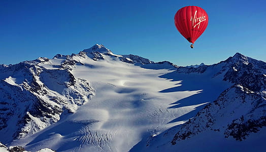 red Virgin air balloon near mountain thumbnail