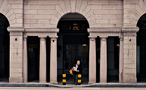 woman passing through grey concrete arch thumbnail