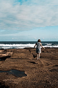 woman standing near ocean during daytime thumbnail