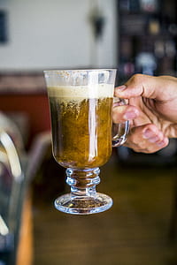 person holding brown liquid filled cocktail glass thumbnail