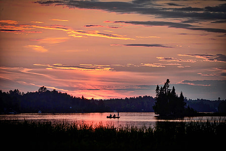 silhouette of boat on body of water thumbnail