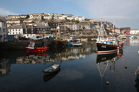 black fishing vessel near wooden paddle boat thumbnail