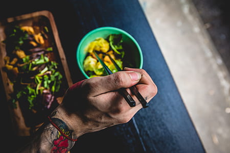 tilt photography of person holding chopstick thumbnail