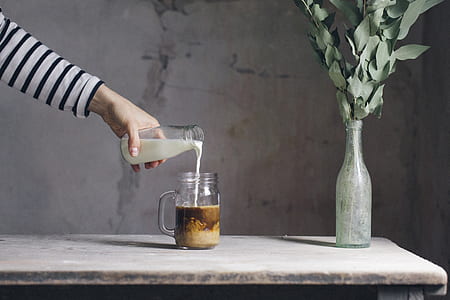 person's hand puoring milk into glass thumbnail