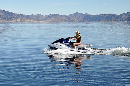 person riding at white and blue personal watercraft on body of water thumbnail
