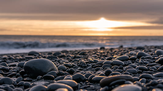 selective focus photography of black stones in seashore thumbnail