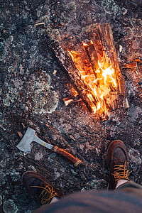 man standing near hatchet and bonfire thumbnail