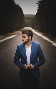 shallow focus photography of man in blue notched lapel suit jacket looking sideways thumbnail