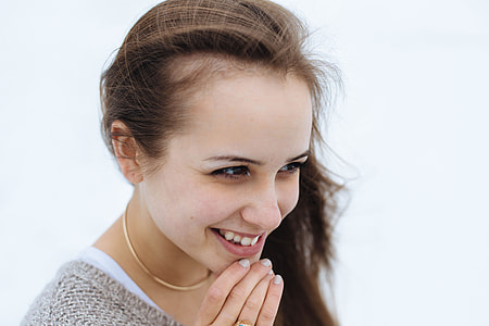 woman smiling while holding chin thumbnail