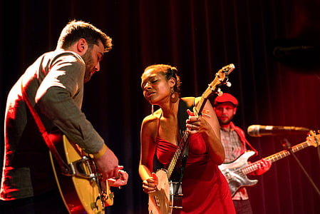 three person playing string instrument on stage thumbnail