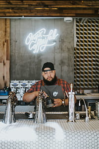 man holding coffee mug beside counter thumbnail