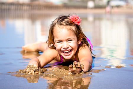 girl laying on beach during daytime thumbnail