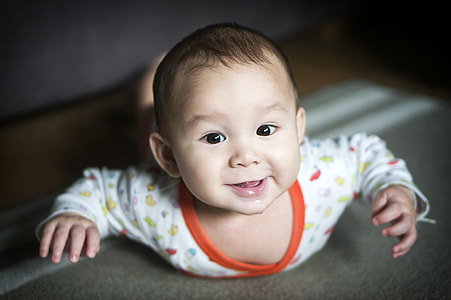 smiling baby wearing white and orange long-sleeved top thumbnail