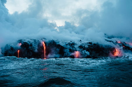 erupting volcano near body of water thumbnail