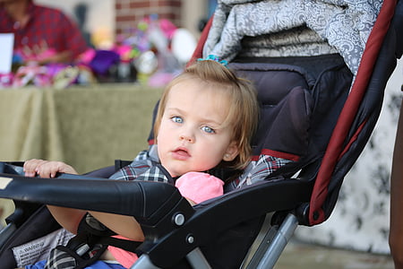 girl sitting on black and red stroller thumbnail