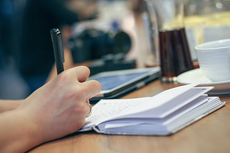 shallow focus photo of person writing on notebook thumbnail