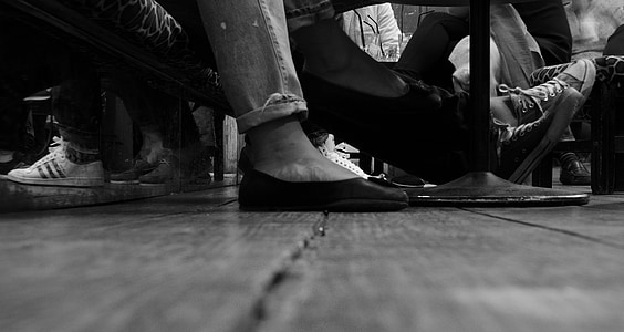 grayscale photo of person foot wearing a slip on shoe thumbnail