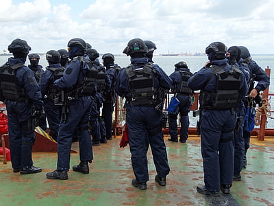 group of police standing near red metal rails thumbnail